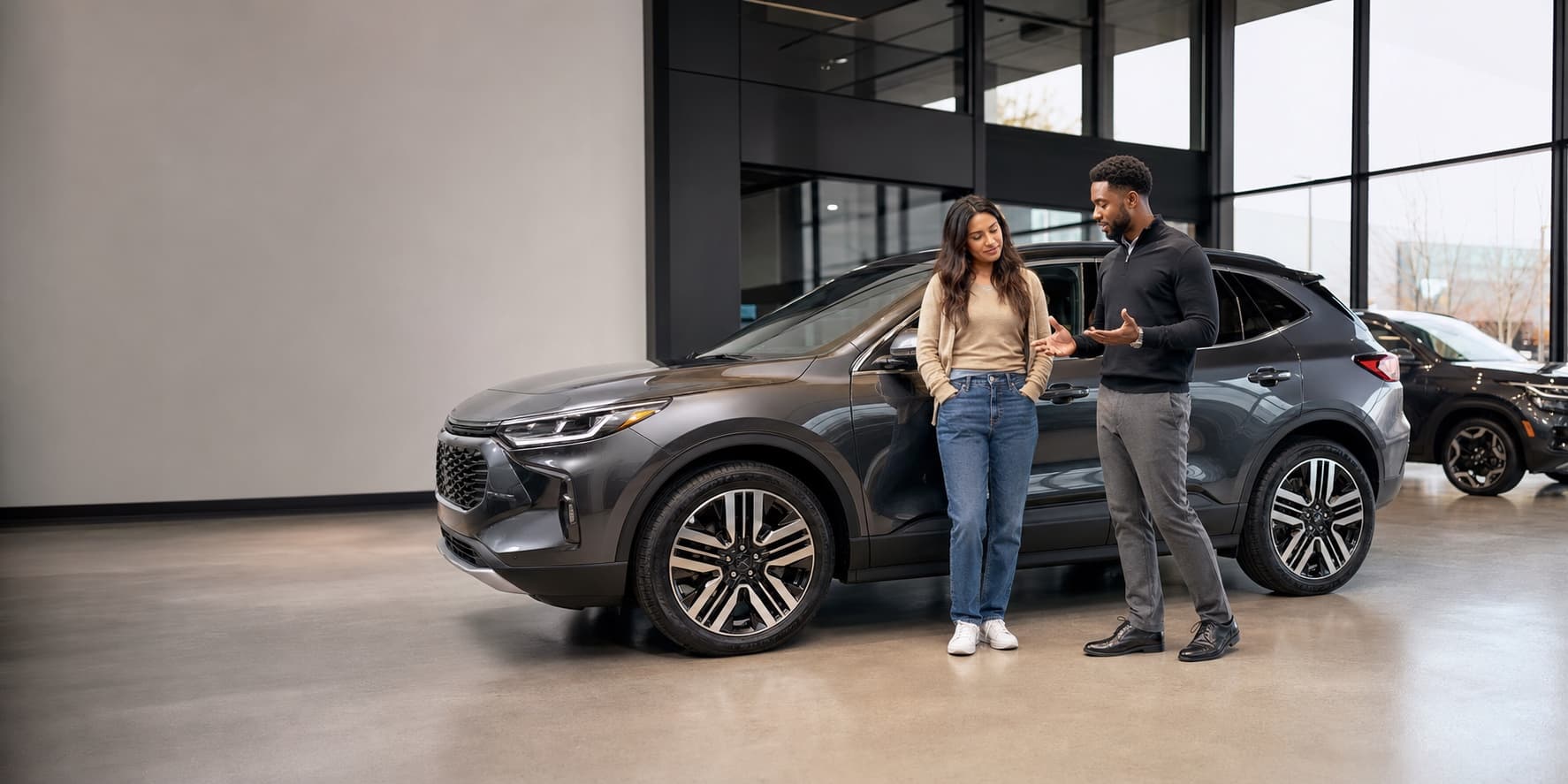 A buyer and dealership specialist reviewing a vehicle together in a modern showroom